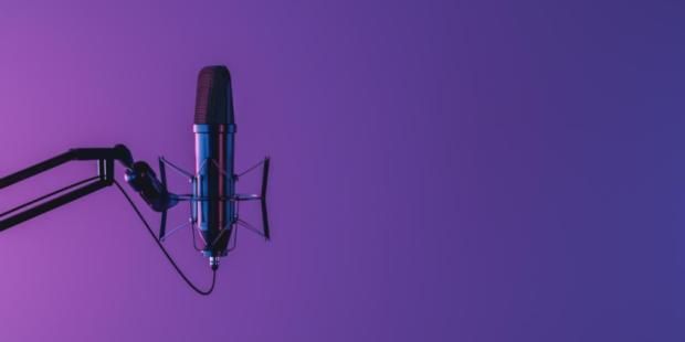 Studio microphone isolated on dark background with neon lighting and space for text